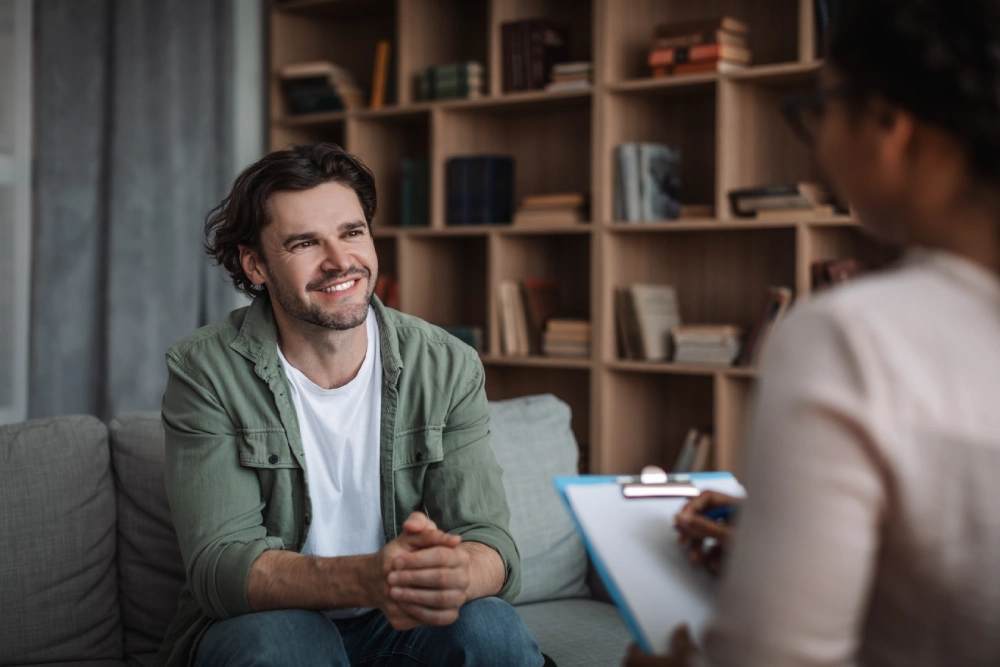 Man smiling, listening to therapist.