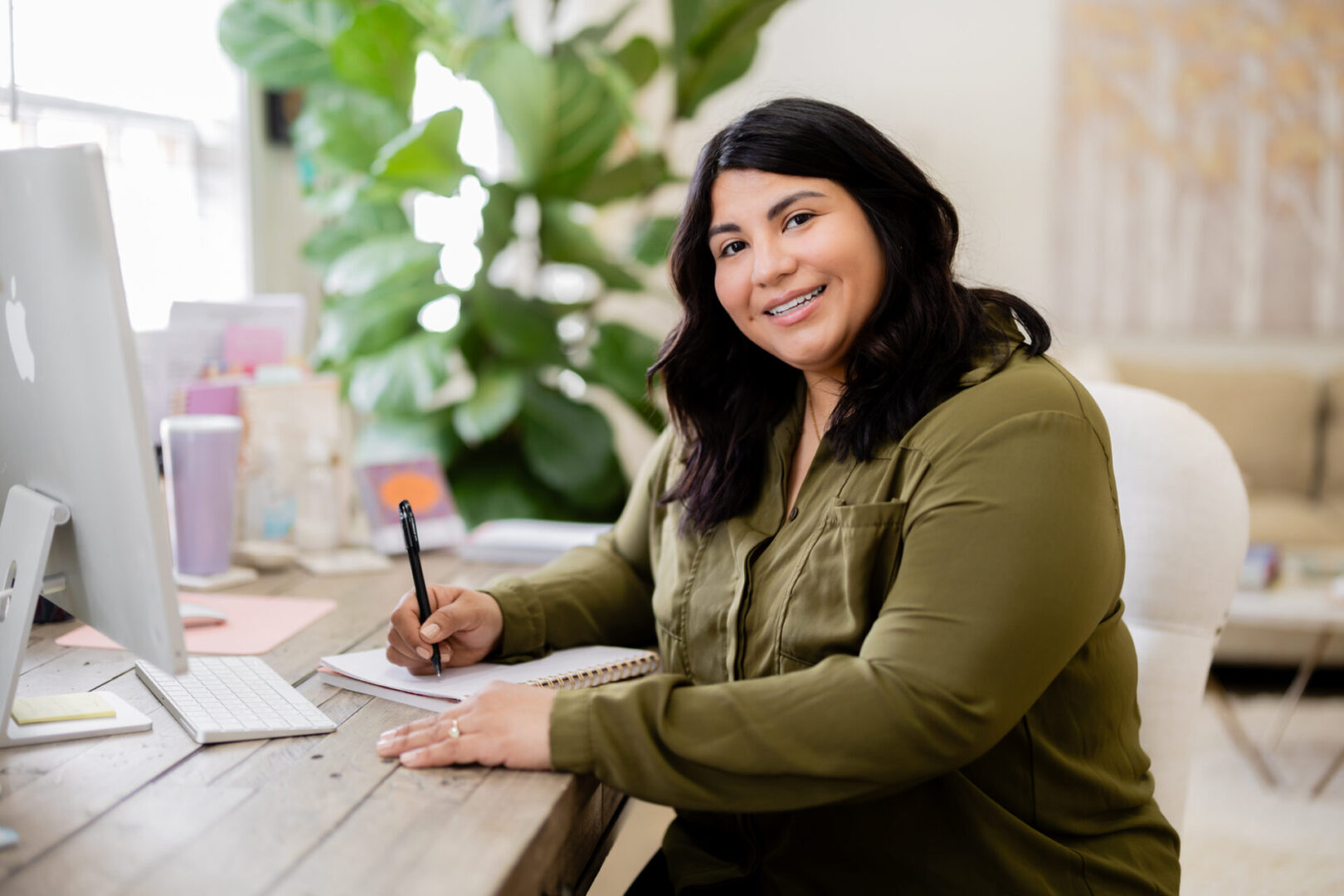 A woman sitting at a table writing on paper.